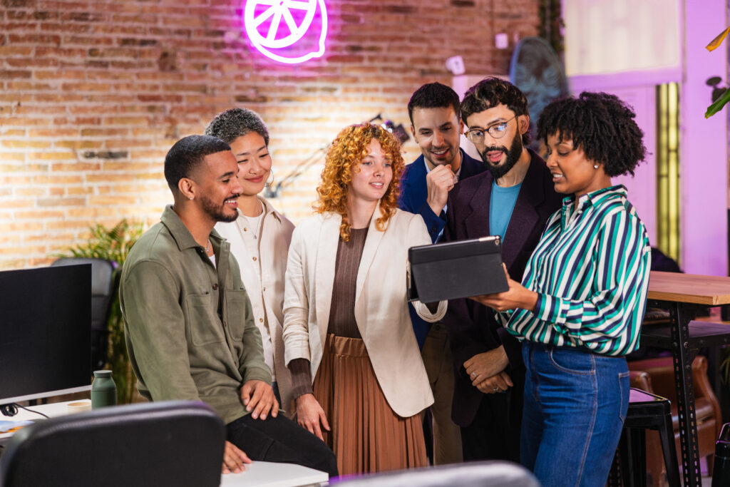 Multi ethnic team working together on a digital tablet in modern office